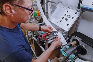 Mitarbeiter kontrolliert Etiketten-Lohndrucke